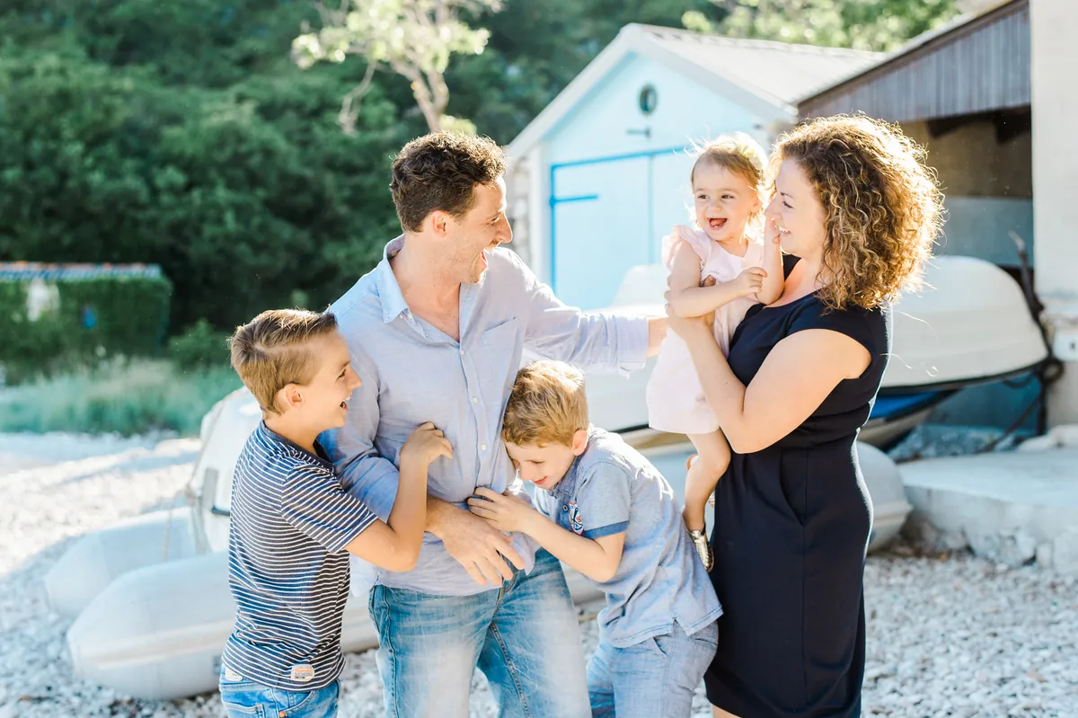 Familie lachend vor einem Bootshaus